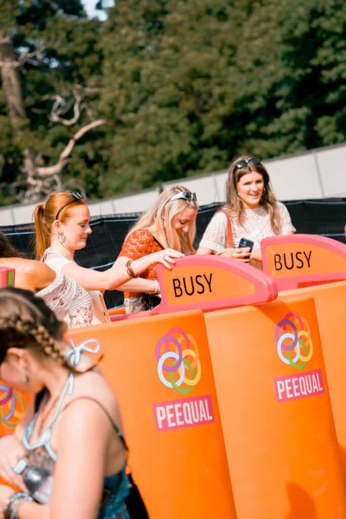 Women using PEEQUAL women's urinals at Love Saves the Day 2026 with new occupancy indicators to show when a unit is busy or free, no shewee in sight!