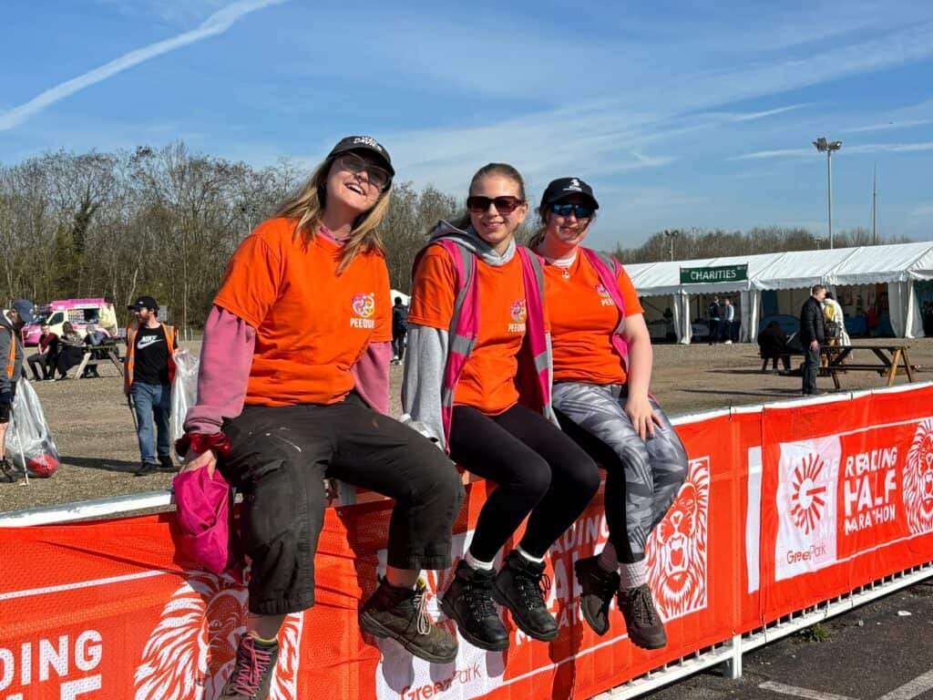 PEEQUAL Crew on a fence at Reading Half Marathon